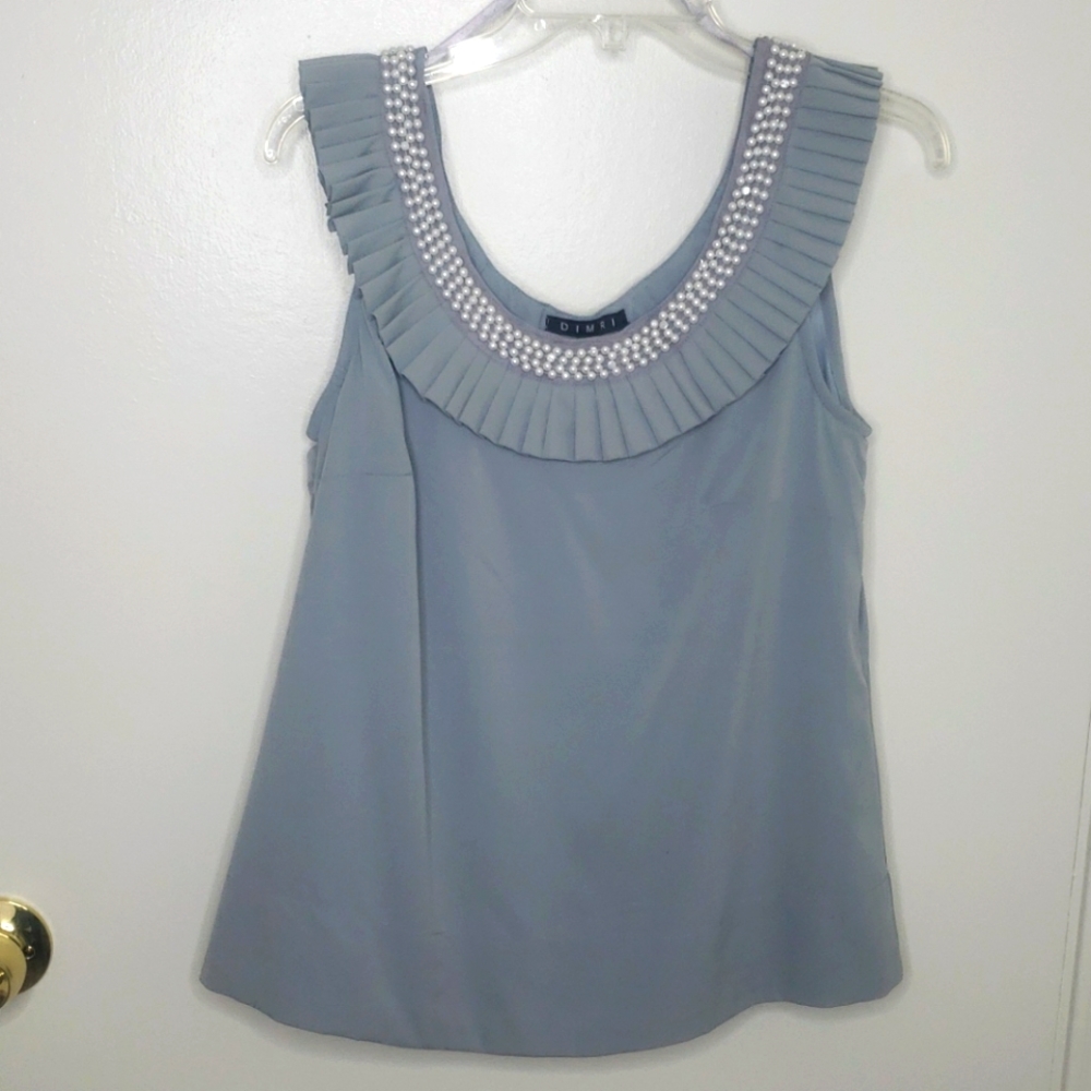 Sleeveless blouse with pleated neckline.